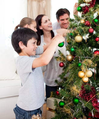 Family decorating a Christmas tree with boubles in the living-room-1