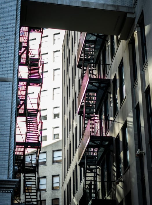 Edge of high-rise building with exterior stairs.